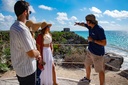 Group of friends learning alongside a tour guide about the majesty of the Tulum ruins on the iconic white coast of the Riviera Maya in the Mexican Caribbean.