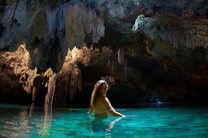 Young woman enjoying the peace and tranquility of the turquoise, crystal-clear waters of an incredible cenote in the Riviera Maya.