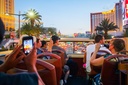 Travelers snap photos of the Vegas strip during a hop-on hop-off bus tour.